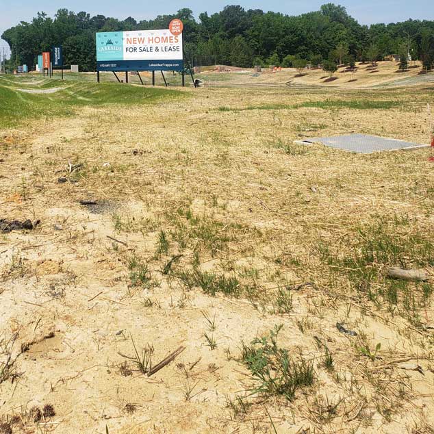 The front lake is brown, discolored and surrounded by clay construction mud.